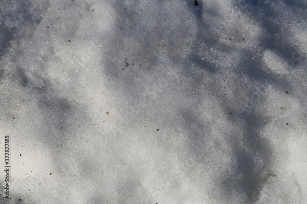 Fototapeta White beautiful surface of snow photographed during a sunny spring day in Finland. Lovely background texture. Closeup color image from a high angle view.