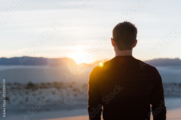Fototapeta A man looking into the sunset at White Sands National Park in New Mexico. 
