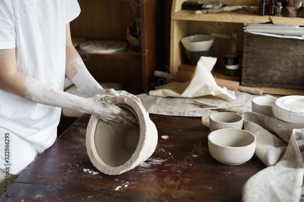 Fototapeta Female hands hold a bowl for casting clay products. Shaped method for making clay dishes. Handwork. Pottery making