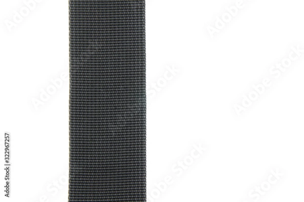 Fototapeta Wide black textile belt. Nothing extra. Belt made of fabric on a white isolated background. The abstraction is interesting. Vertical layout.