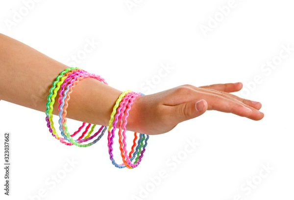 Obraz girls arm with colorful plastic bracelets for kids isolated on white background