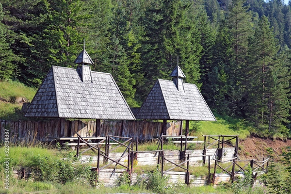 Fototapeta Two places for rest with roof shelters and picnic tables in the edge of forest. Big rustic looking wood gazebos