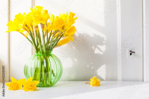 Obraz bright sunlight shines on Easter bells, daffodils flowers in vase on the windowsill. country style bouquet for spring decoration or Easter decoration against open background with copy space