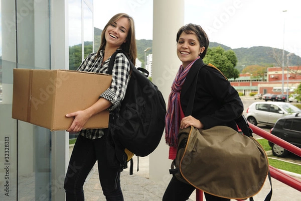 Fototapeta Student with cardboard box  moving in to thecollege campus