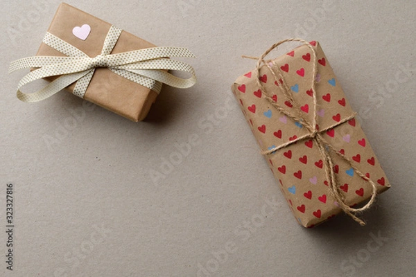 Fototapeta Gift boxes in crafting for Valentine's Day on a cardboard beige background with space for your creativity and space for text.
