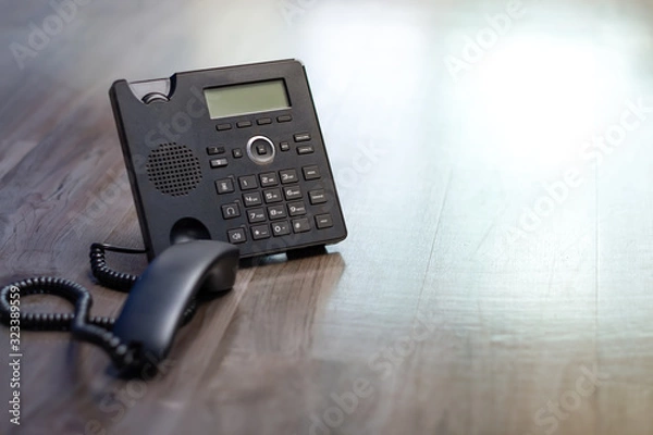 Fototapeta Close Up keypad number Black ip phone is placed on a wooden floor in the office.