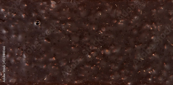 Fototapeta Top view texture of back of chocolate bar with almond nut