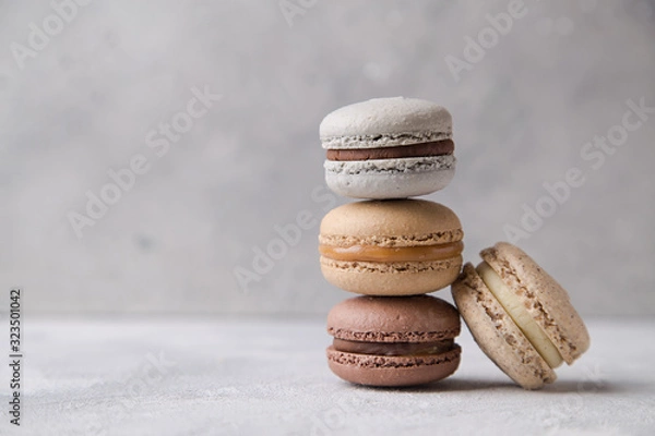 Fototapeta Macarons chocolate, caramel and vanilla on light background