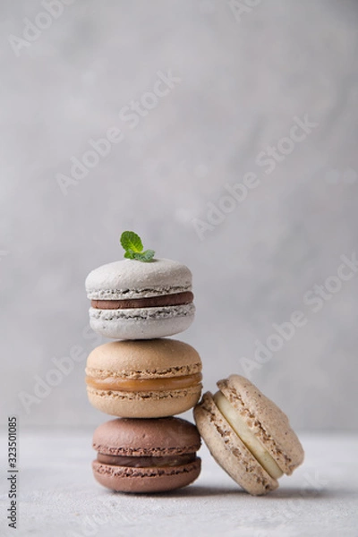 Fototapeta Macarons chocolate, caramel and vanilla on light background