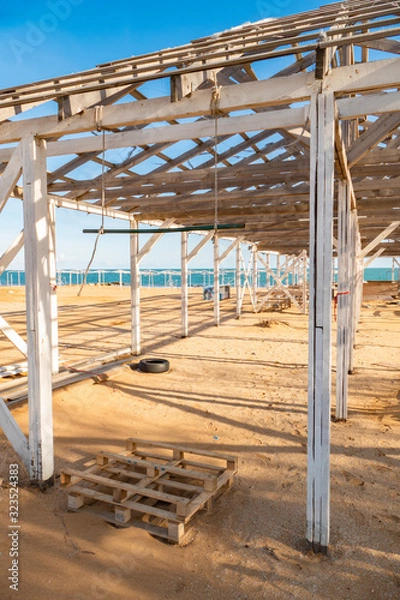Obraz Unfinished wooden structure for sunshade. Wooden awning structure for resting on the seashore in the off-season