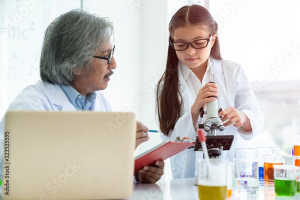Fototapeta Science teacher teach useing microscope with Asian students on table in laboratory room, concept for study in laboratory room.