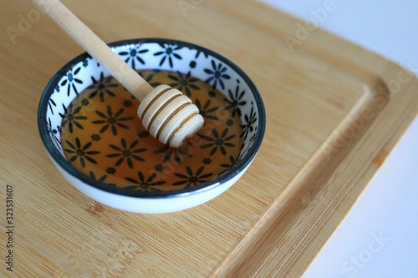 Obraz Honey with wooden honey dipper