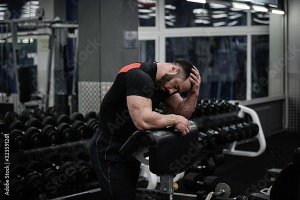 Obraz steroid doping problem and trouble headache tired sport man hold his head with hand in fitness gym after heavy failure loss workout
