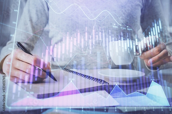 Fototapeta Forex chart hologram on hand taking notes background. Concept of analysis. Double exposure