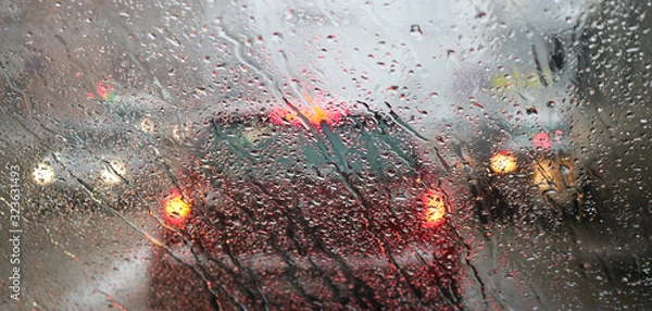 Fototapeta View from the car windscreen during rain and wet snow. Poor visibility while driving around the city. Snowy road.