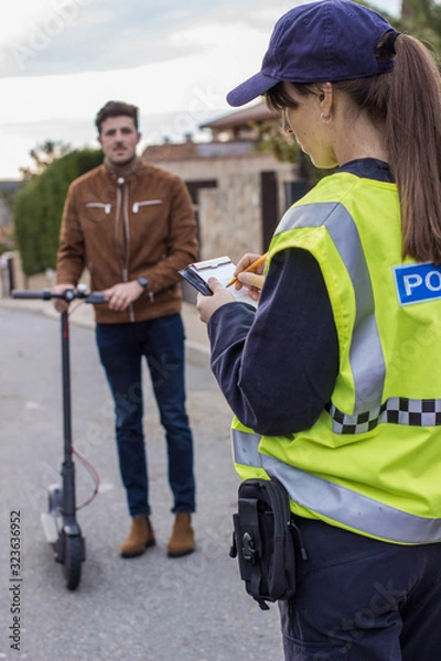 Obraz policeman stops a boy on electric scooter