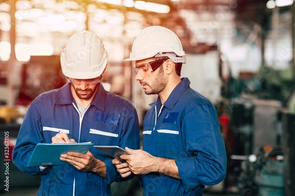 Fototapeta Engineer teamwork cooperate with worker to checking factory machine for safety and talking together.