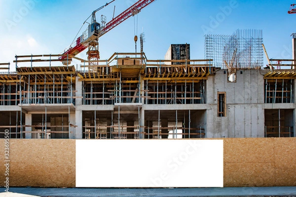 Obraz Blank white banner for advertisement on a fence of a building under construction