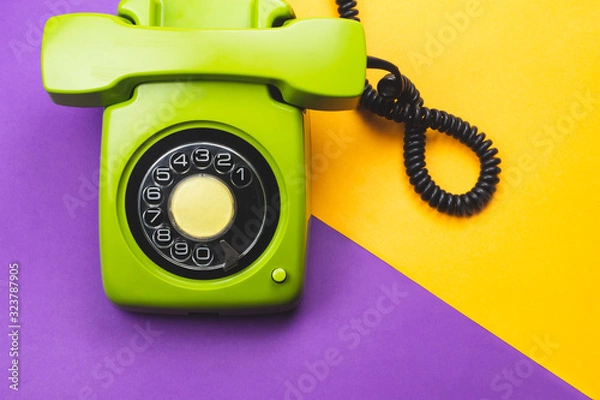 Fototapeta Classic phone with handset. vintage green telephone with phone receiver on color background. old communication technology