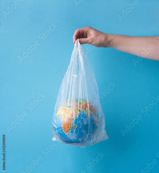 Fototapeta no plastic concept. hands holding planet earth in plastic bag.
