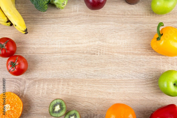 Fototapeta Frame of fresh colorful vegetables and organic fruits on wooden background. Top view with copy space for text. Cooking ingredients, healthy food and nutrition concept.
