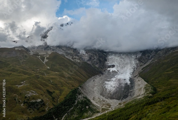 Obraz Dramatic autumn landscape with glacier Lardaad Adishi and mountain Tetnuldi hiding in clouds in Svaneti Georgia big kar and small tongue because of global warming