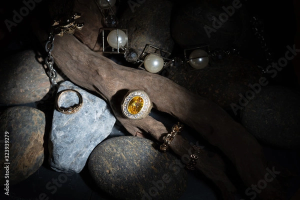 Obraz Yellow Sapphire and Diamond Ring Resting on a branch With a pearl bracelet decorated Placed on a beautiful patterned stone Along with firing the flash light To emphasize the ring to stand out