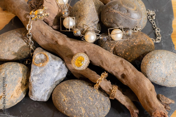 Obraz Yellow Sapphire and Diamond Ring Resting on a branch With a pearl bracelet decorated Placed on a beautiful patterned stone