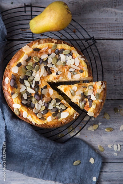 Fototapeta Pears and cheese pie with bowl of caramel, old spoon and fork. Top view. Copy space flat lay