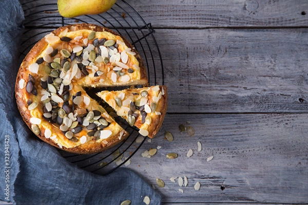 Fototapeta Pears and cheese pie with bowl of caramel, old spoon and fork. Top view. Copy space flat lay