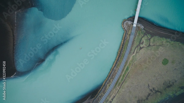 Fototapeta Aerial view from above on a green and blue glacier river stream in  South Iceland. Beautiful patterns, textures and structures. Melting glacier,  Global warming and climate change concept