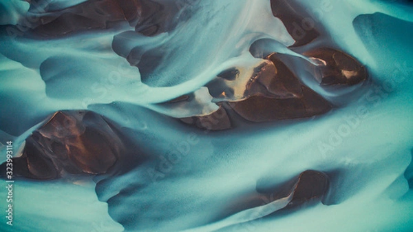 Fototapeta Drone view of blue abstract glacier river in Iceland.