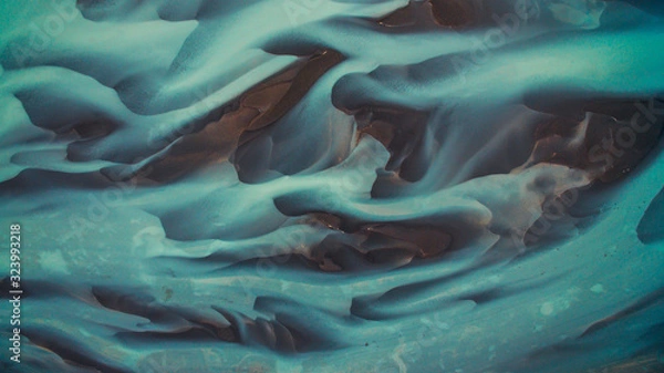 Fototapeta Bird's eye view from above on a green and blue glacier river stream in South Iceland. Beautiful patterns, textures and structures. Melting glacier, Global warming and climate change concept