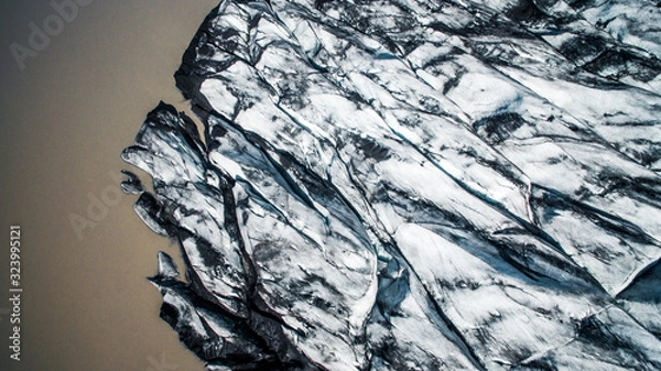 Fototapeta Aerial, Top view. Skaftafell National Park. Ice and ashes of the volcano texture landscape, beautiful nature ice background from Iceland. Sólheimajökull glacier.