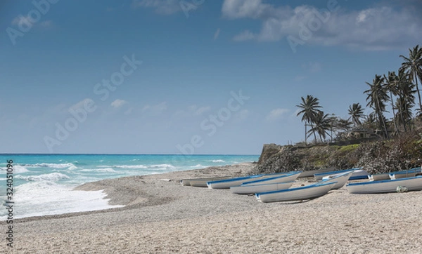Obraz dramatic image of fishing boats on the caribbean coast in Los Patos, dominican republic.