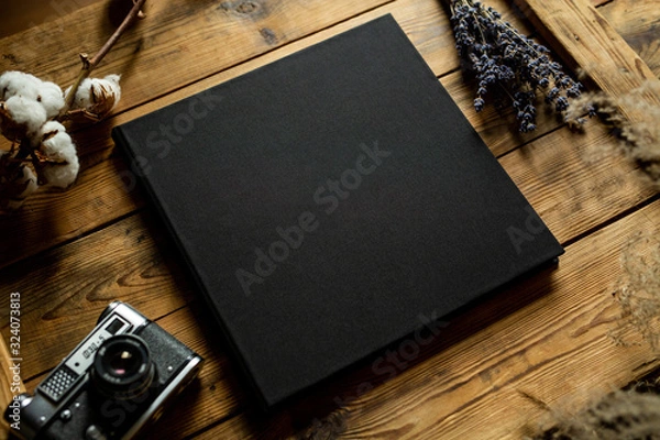 Fototapeta Black book on a wooden table, view from top