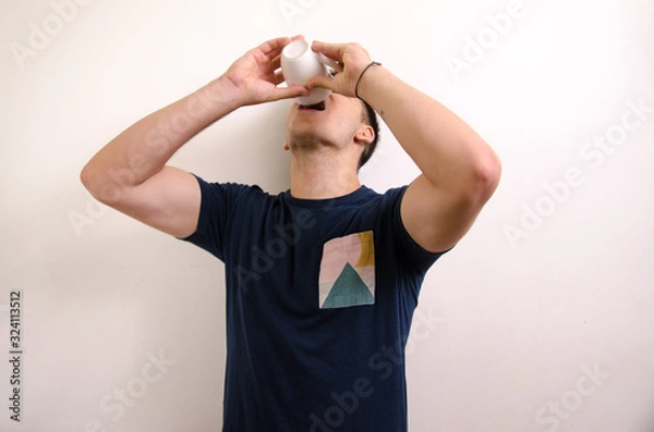 Obraz Young man drinking from a jug