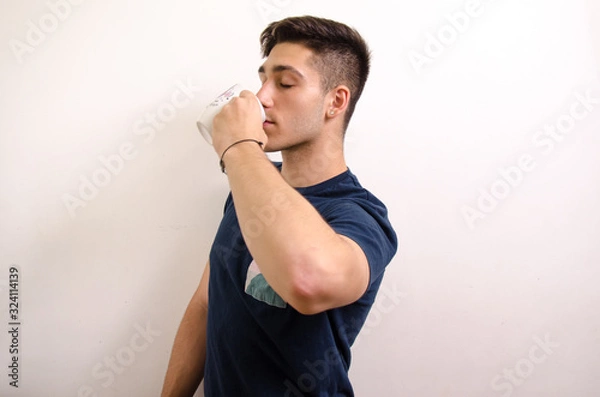 Obraz Young man drinking from a jug