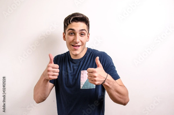 Obraz Happy young man with raised thumbs showing success