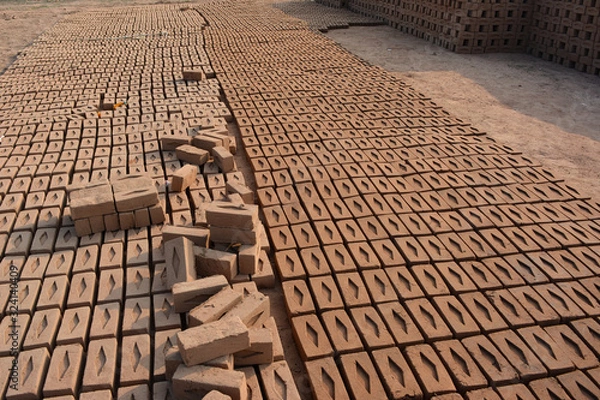 Obraz Raw brick laid out in stacks for drying. Bricks in a brick factory. Traditional production of clay bricks in India.
