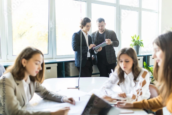 Obraz Team of young business professionals using technology in an informal meeting engaged on architect design. . Concept of successful startup