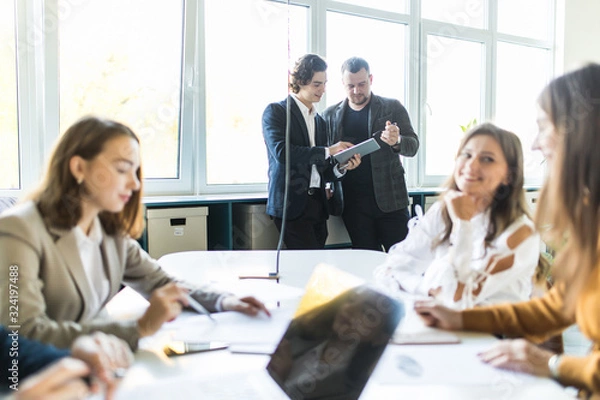 Obraz Team of young business professionals using technology in an informal meeting engaged on architect design. . Concept of successful startup