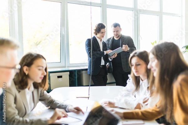 Obraz Team of young business professionals using technology in an informal meeting engaged on architect design. . Concept of successful startup