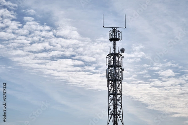 Obraz Close-up of lattice mast with base station for mobile communications against blue sky with clouds. Seen in Germany in February