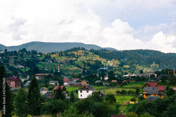 Obraz Ukrainian village in the Carpathian mountains in sunny evening. Beautiful landscape during the evening light. Country side view of vertex in the middle of summer. Rural landscape with forest. Hills.