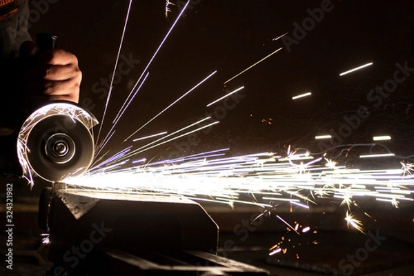 Obraz The process of stripping metal using an abrasive wheel on a grinding machine. Sparking is hazardous to the eyes.