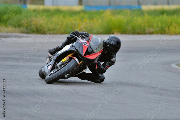Obraz Motorcycle practice leaning into a fast corner on track