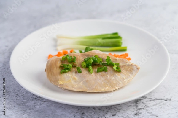 Obraz Steamed chicken breast on a white plate with spring onions and chopped carrots