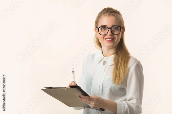 Fototapeta beautiful young woman in a shirt on a white background with a notebook notepad