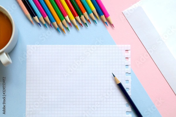 Fototapeta Top view of a sheet of paper, colored pencils, an envelope and a Cup of tea on the table. Write a letter. 
